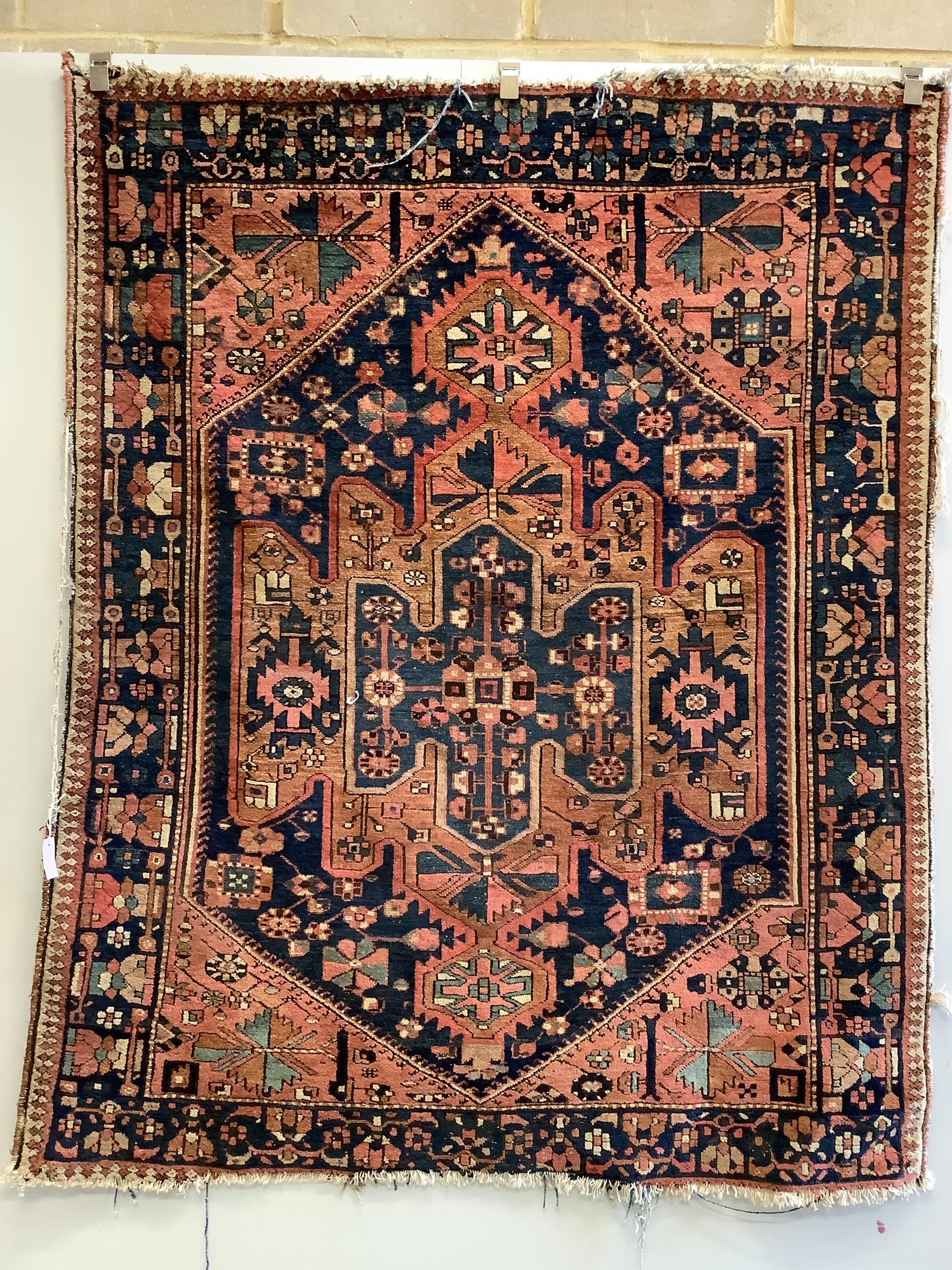 A Hamadan pink ground rug with a geometric woven hexagonal field, 195 x 156cm. Condition - poor to fair